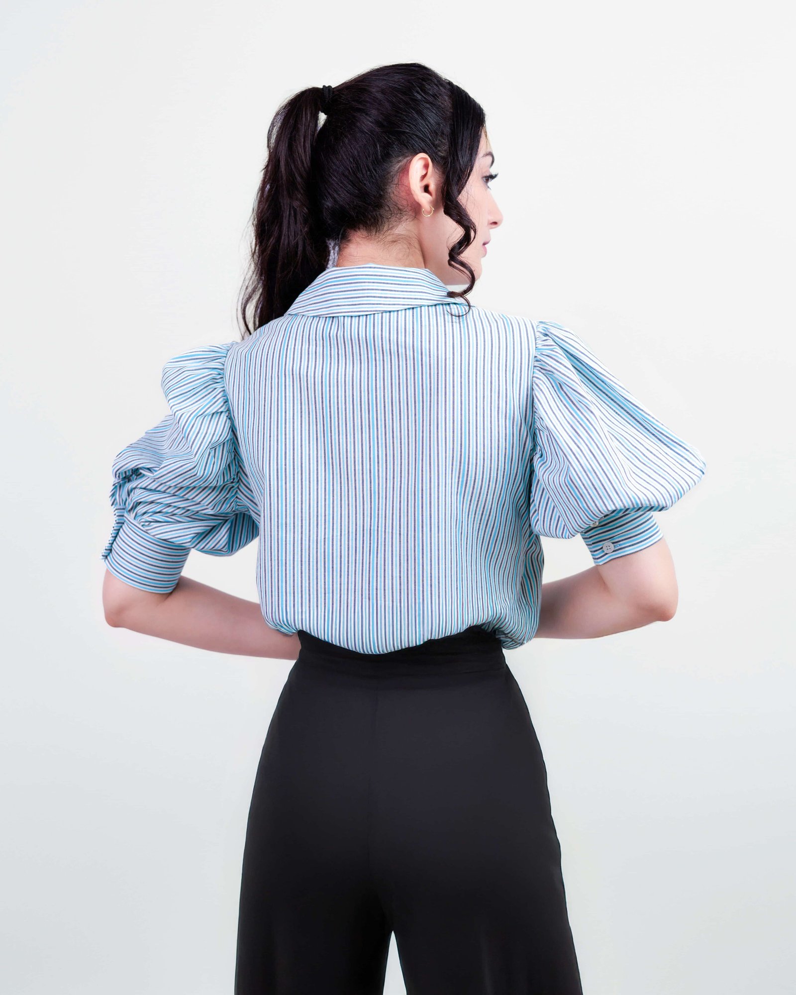 Vue arrière d’une femme portant une chemise rayée à manches bouffantes – Collection ECHOES OF S(E)OUL & BEYOND – Maison Kumawo